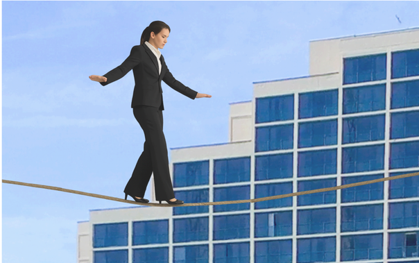 Photo of Woman in business attire walking on a tightrope